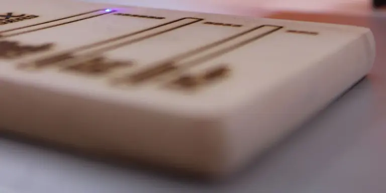 Ein Diodenlaser hat Linien und Schrift in eine helle Holzplatte gebrannt