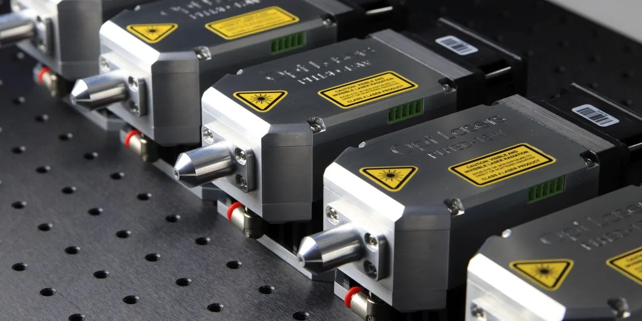 Mehrere Lasermodule mit Warnschildern stehen nebeneinander auf einer Lochplatte